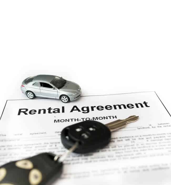 A car rental agreement with a small car and a key on top.