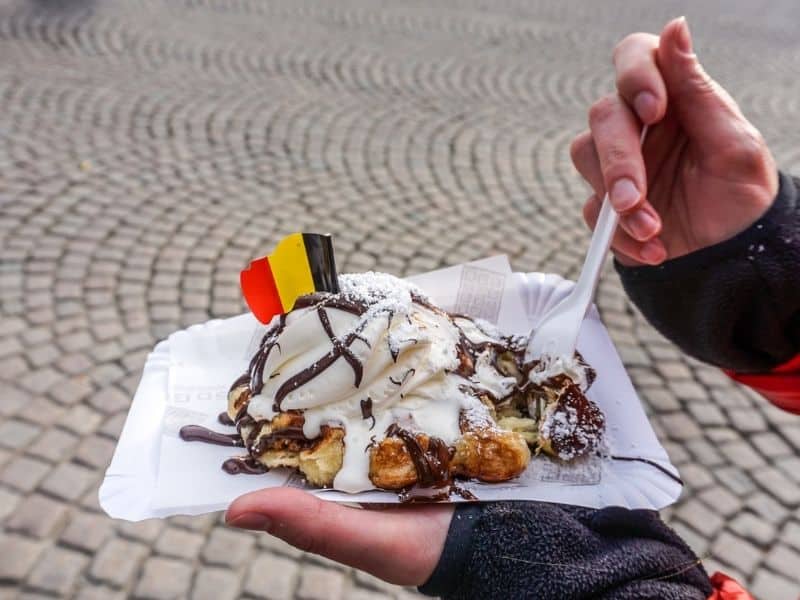 Belgian Waffle with Ice cream on top and the Flag of Belgium pinned at the top.