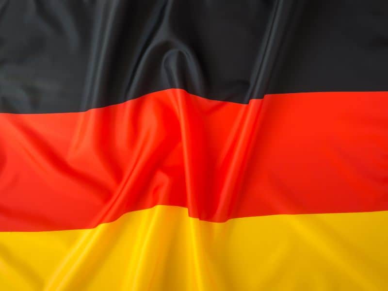 Photo of German flag with vertical stripes. Color order from the top: black, red and yellow.