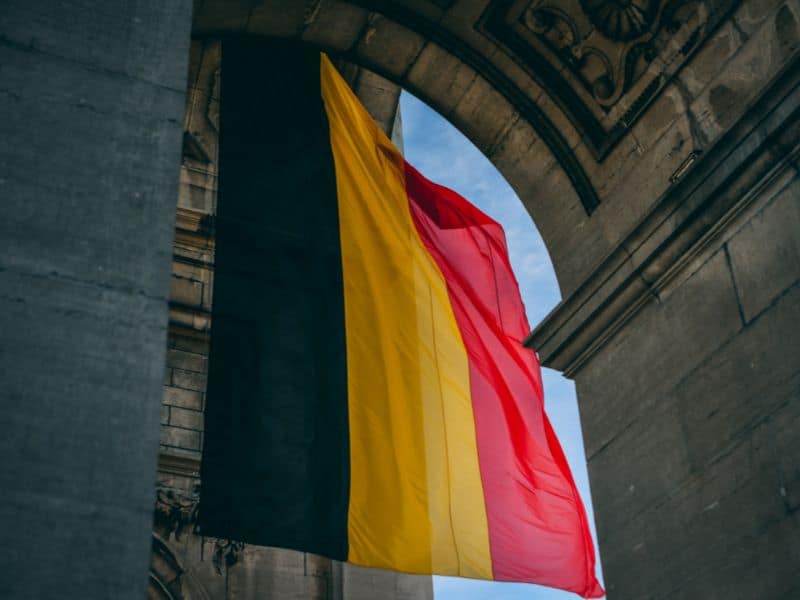 Big Belgian Flag close up that's hanging in the arch of a stone building