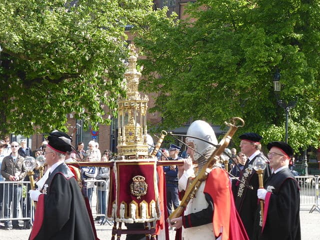 Men in black gowns carrying the Holy Blood relic during procession in Bruges