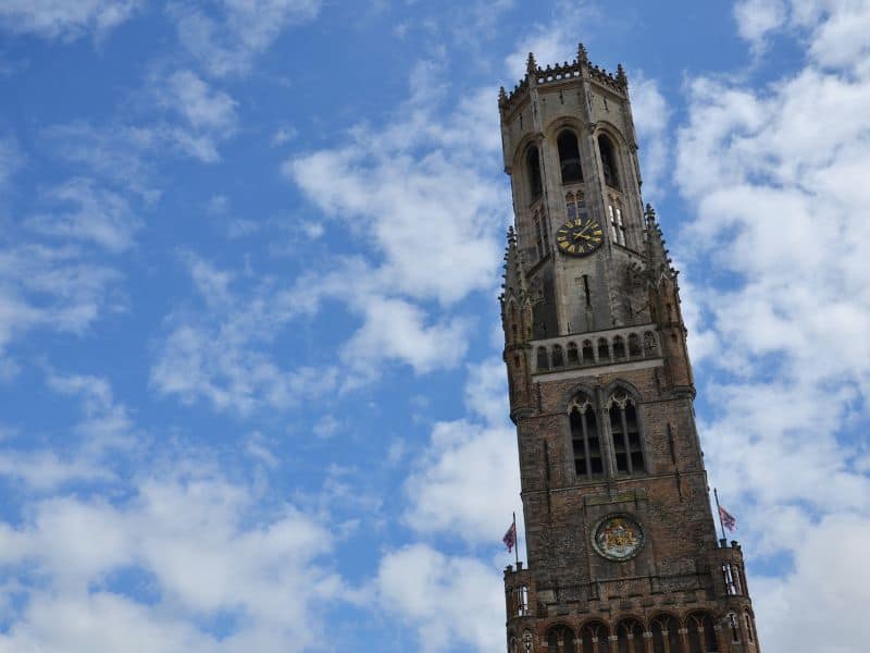 A view of the Bruges belfry with a backdrop of the blue sky