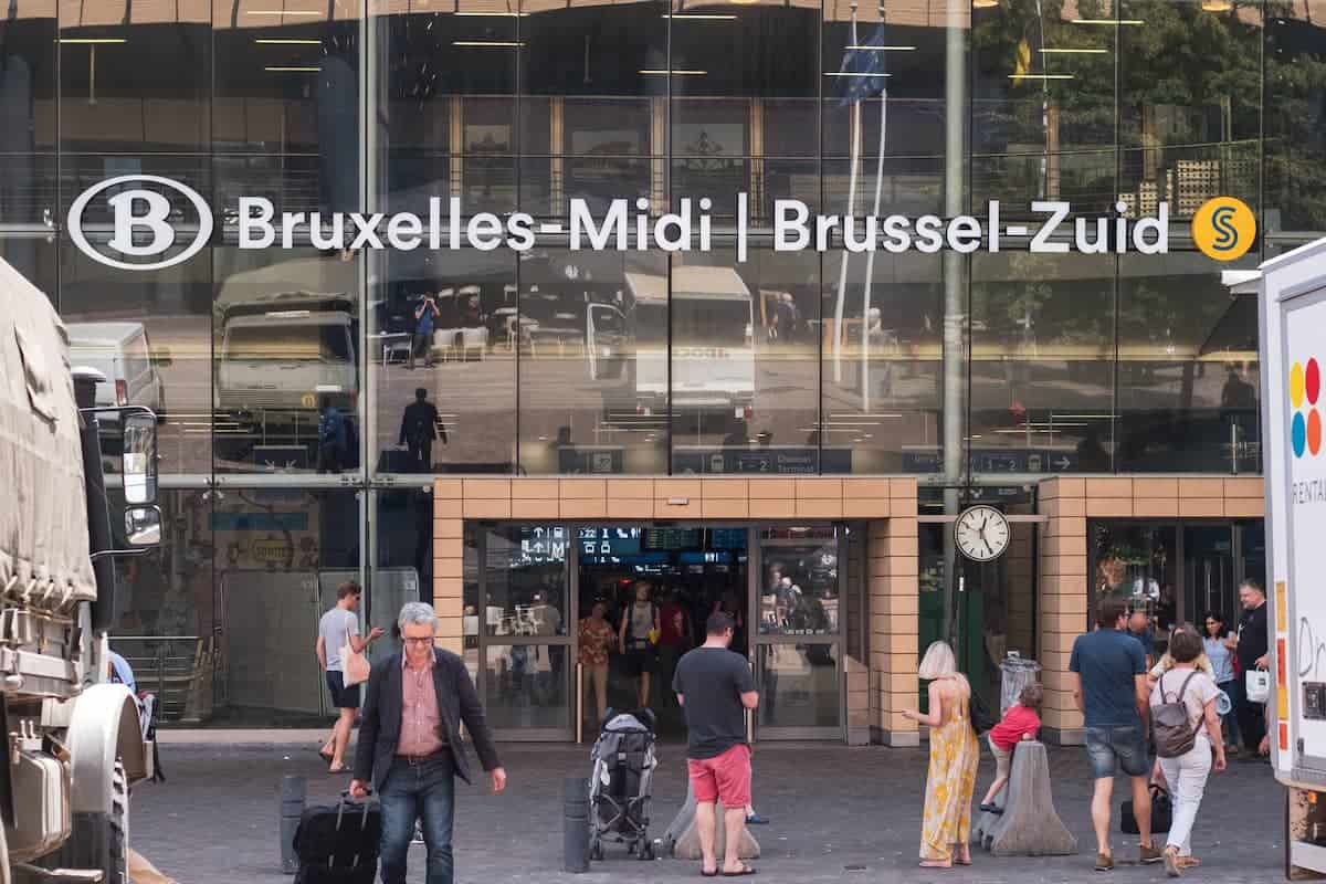 The entrance of Brussels South Station with people walking in and out.