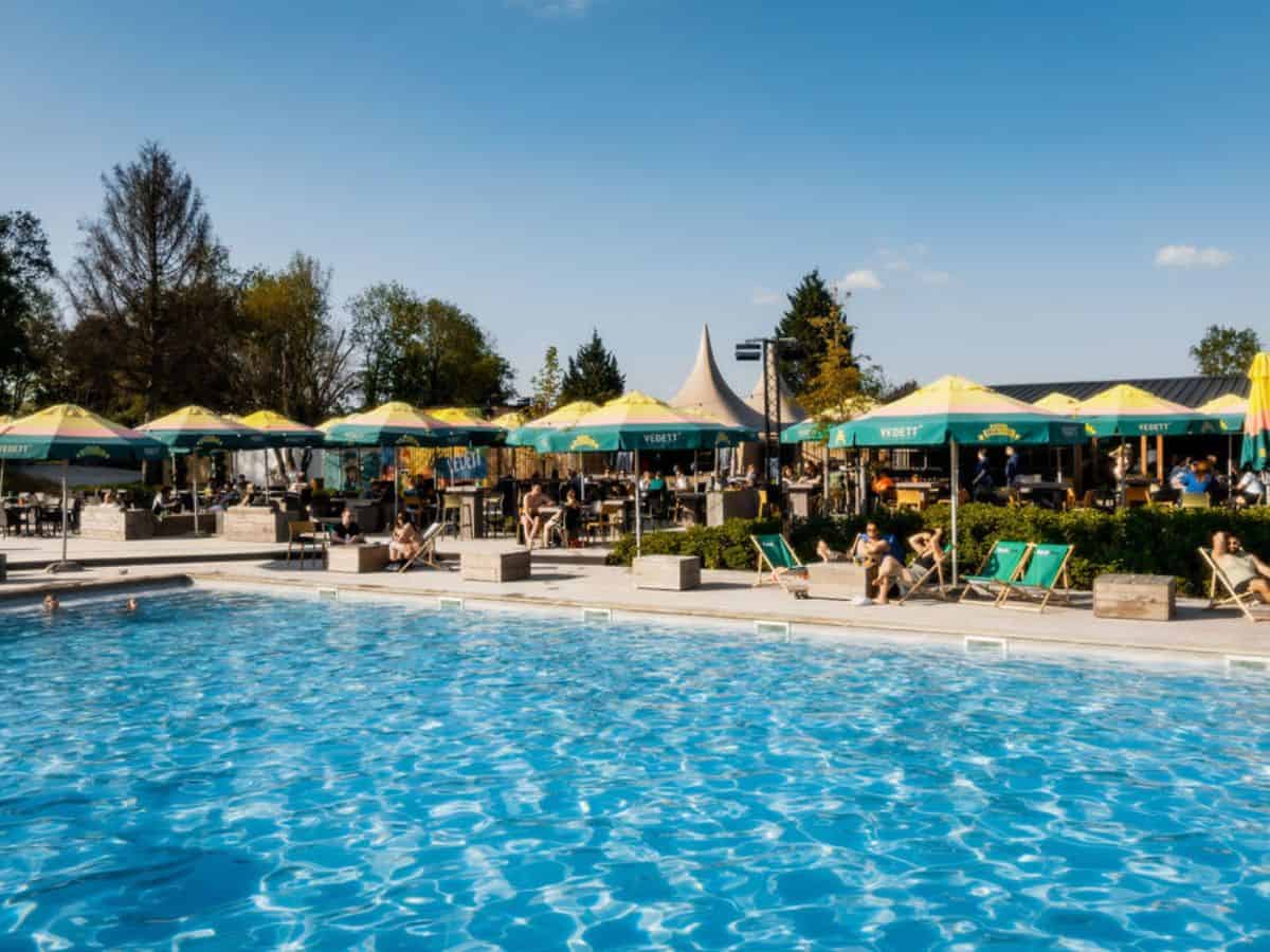 Pool area of the Green Fields - Durbuy glamping site, depicting a tranquil, lush green meadow
