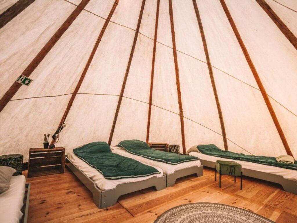 The image displays a luxurious bedroom at Landgoed Omorika, featuring a large, plush bed in a room creating an intimate and cozy atmosphere.