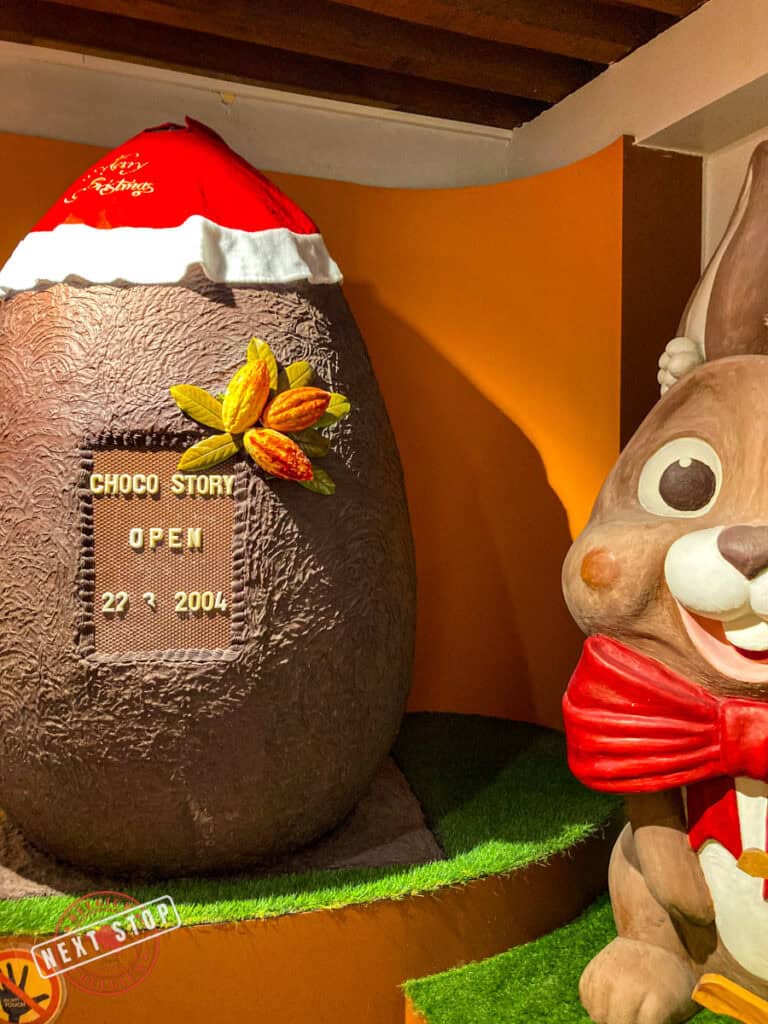 Easter Bunny with a huge chocolate egg beside it in Bruges Choco-Story Museum.