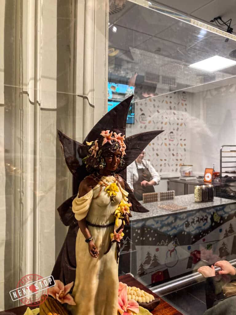 A fairy statue made of chocolate in a glass cabinet.