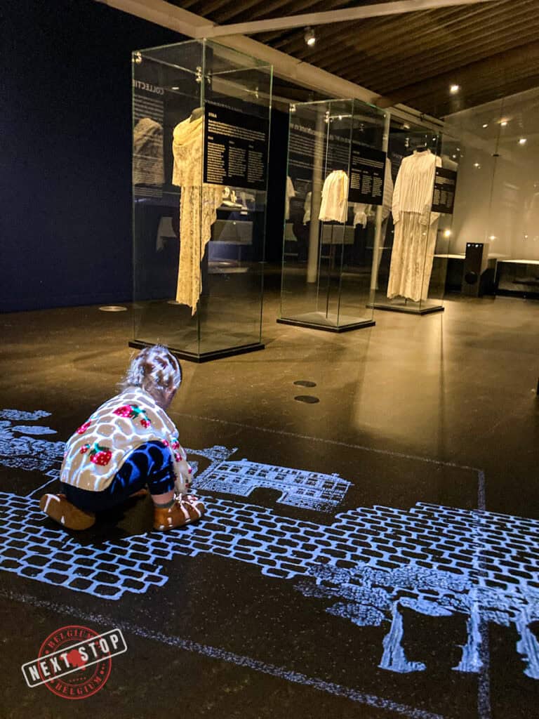 A kid enjoying the video animation projected on the floor of the Texture Museum in Kortrijk.
