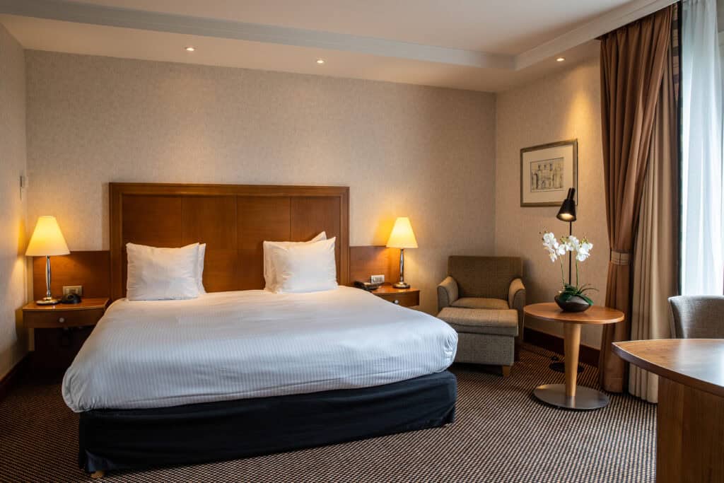 A king size bed in a cozy room in a Brussels hotel.