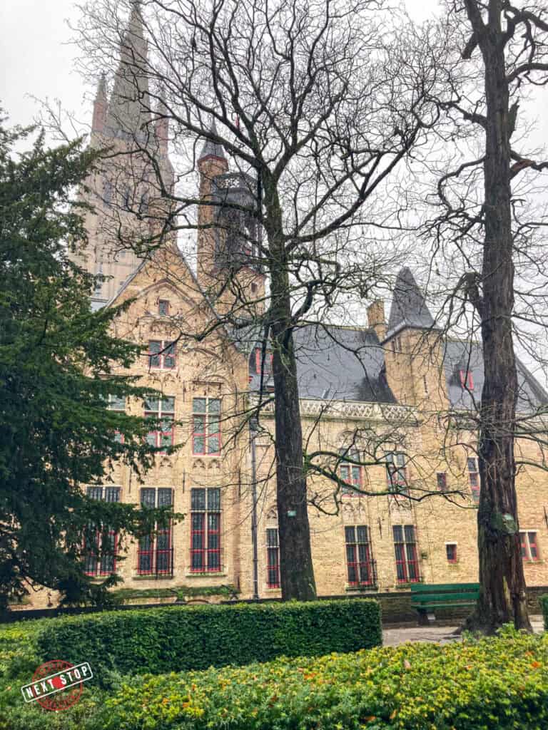 The Arentshof in Bruges surrounded by trees.
