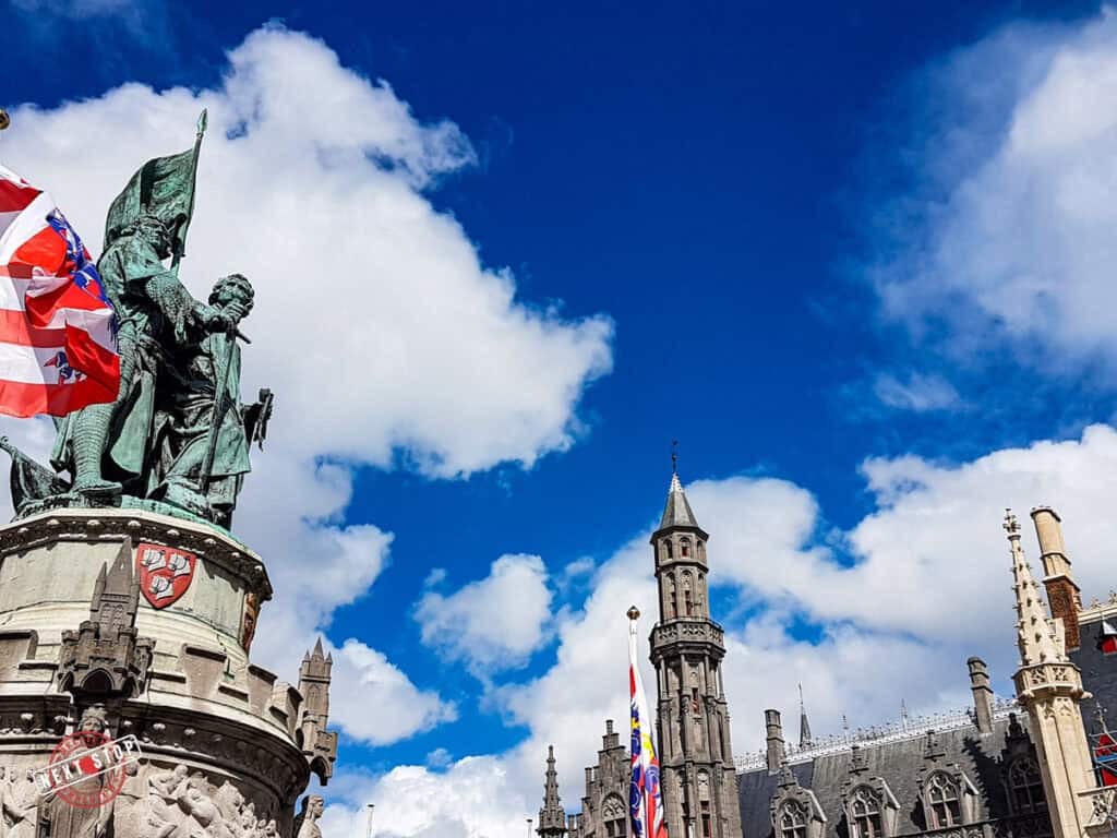 The Jan Breydel and Pieter De Coninck in Bruges near the tall buildings.