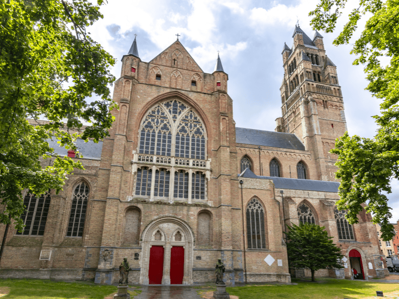A picture of one of the entrances of St. Salvator's Cathedral with its bright red door.