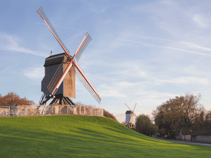 A scenic picture of two of the several classic windmills you can find in the city of Bruges.