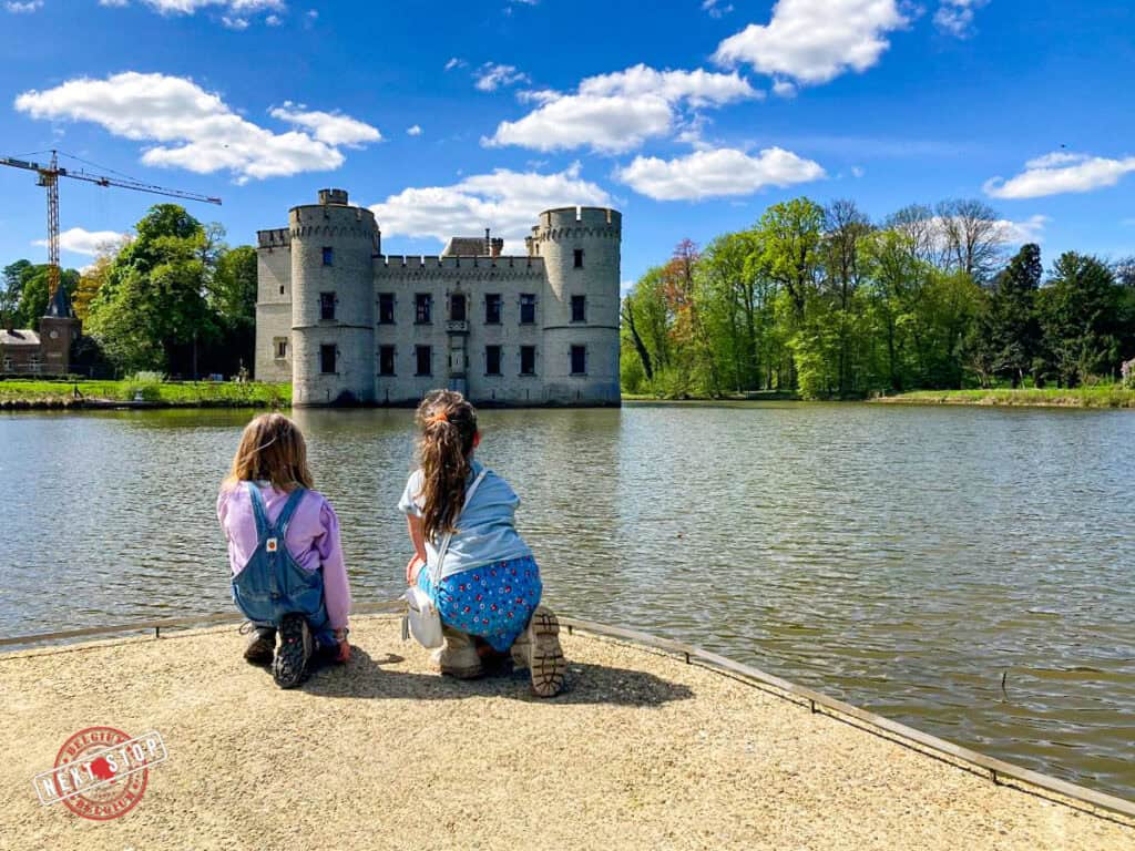 Kids are looking at the castle acorss the lake at the Botanical Garden in Meise.