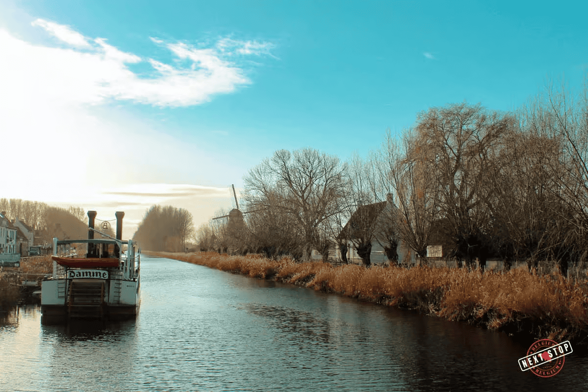 Idyllic scene along the historic Damse Vaart canal in Damme, adorned with the graceful presence of the river boat 'Lamme Goedzak.
